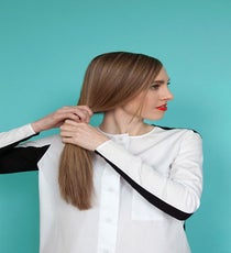 Next, pull hair into a low side ponytail (on the side opposite your part), and secure with a clear elastic. bun-3