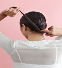Hook your fingers near the top of the twisted tail and wrap the hair upward. LowBun_126_R