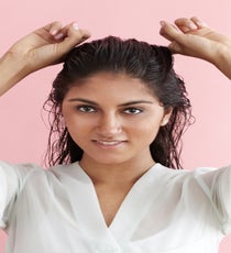 Place your pointer fingers at your temples and section off the hair by pulling it straight back toward the crown. Where the fingers meet at the back of your head, this will create your first section. MultiBun_019_R