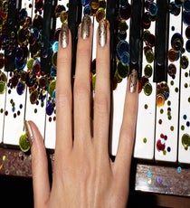To create the confetti-strewn effect seen here, apply one coat of Essie's Good as Gold as a base. Follow with Julep's Vivien, which has hexagonal and micro-glitter shapes to add dimension. To better control the glitter coverage, choose a glitter polish with a clear base. "You can apply another layer over an area that doesn't have much, and you won't notice any streaks," Barokas says.
Essie Nail Color in Good As Gold, $8, available at Essie; Julep Nail Color in Vivien, $14, available at Julep. 09_REFINERY_29_NAILS_DEC_SHOT_6_002_crop2