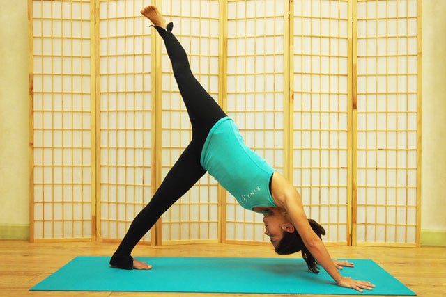 Woman Practising Yoga In Scorpion Pose